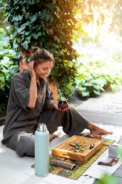 屋外フルショットに座っているスマイリー女性