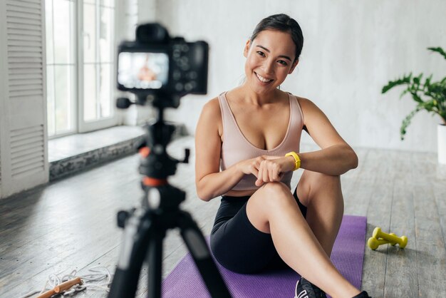 Smiley woman in sportswear vlogging