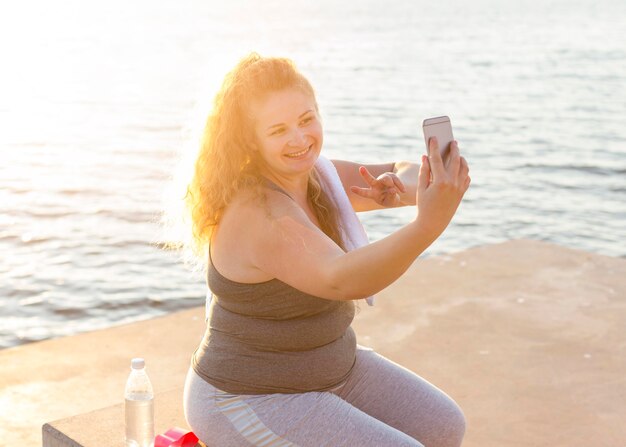 Smiley woman taking selfie after working out