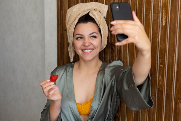 Smiley woman taking selfie medium shot