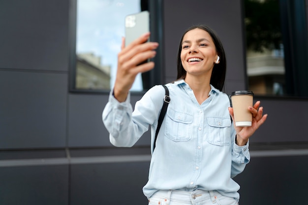 Smiley woman taking selfie medium shot