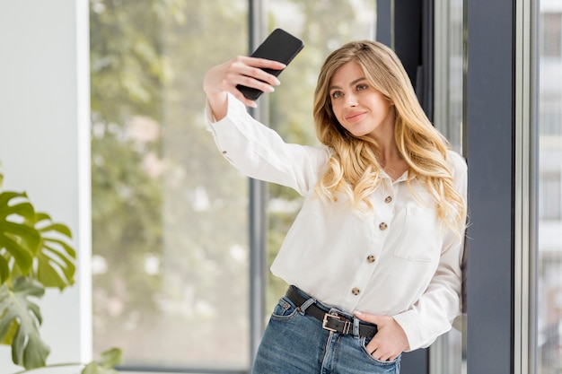 Foto gratuita donna di smiley che cattura selfie