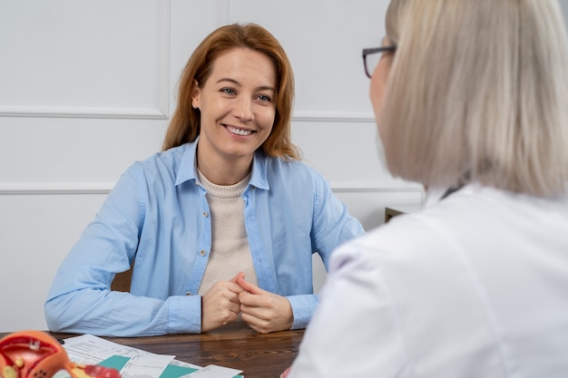 Smiley woman talking to doctor