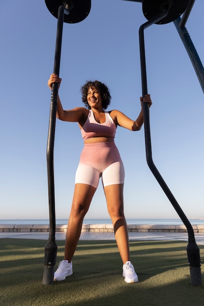 Free photo smiley woman training outside full shot