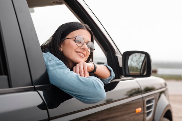 Smiley woman traveling alone by car