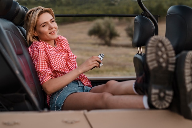 Smiley woman traveling alone by car