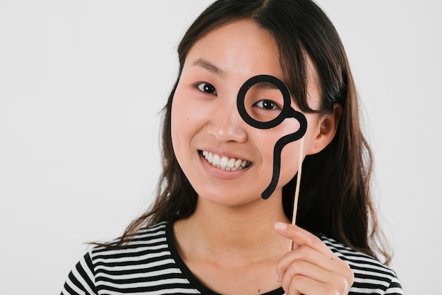 Smiley woman trying out fake monocle