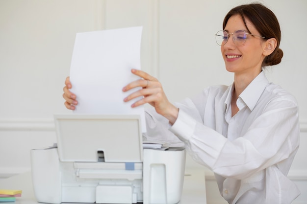 Free photo smiley woman using printer side view