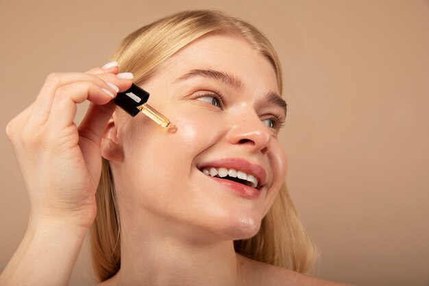 Smiley woman using serum close up