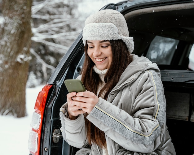 Smiley woman using smartphone while on a road trip