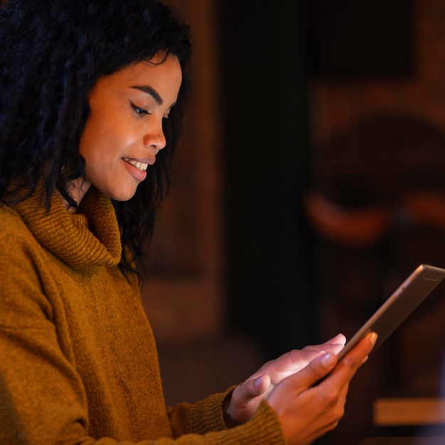 Free photo smiley woman using a tablet in a coffee shop