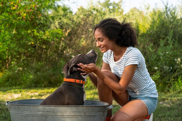 Smiley woman washing dog full shot