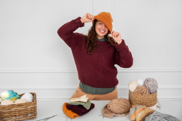 Donna sorridente che indossa il colpo medio del cappello lavorato a maglia