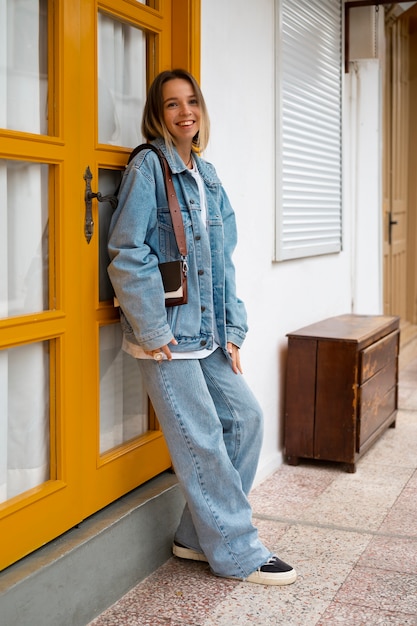 Free photo smiley woman wearing total denim outfits full shot