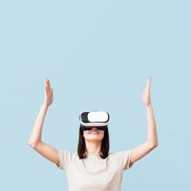 Smiley woman wearing virtual reality headset with copy space