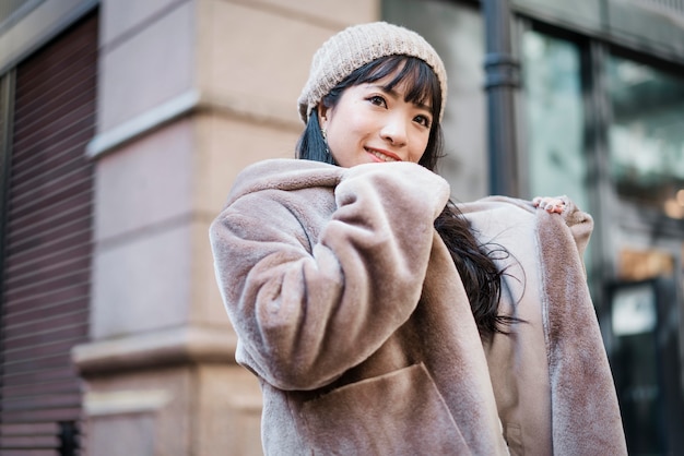 Foto gratuita donna sorridente in abito invernale godendo la sua giornata all'aperto