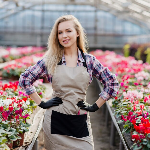 Smiley woman with apron in greenhouse