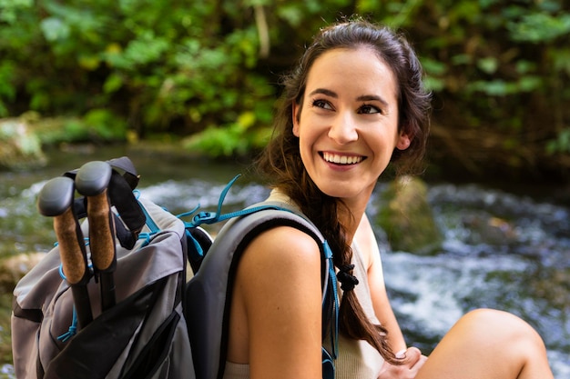 Foto gratuita donna sorridente con lo zaino per godersi la natura mentre all'aperto