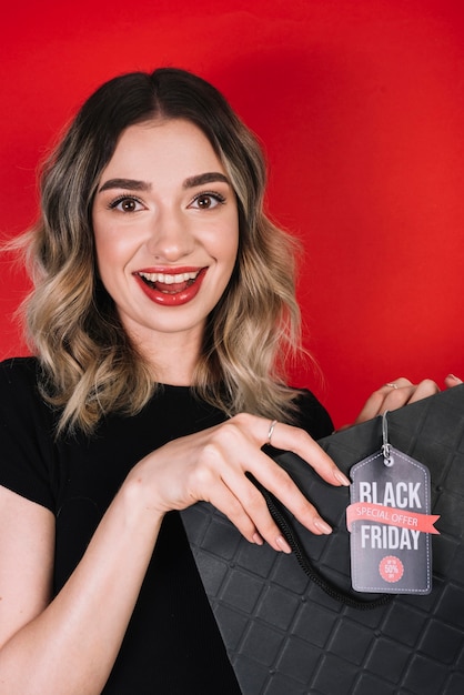 Smiley woman with black friday shopping bag