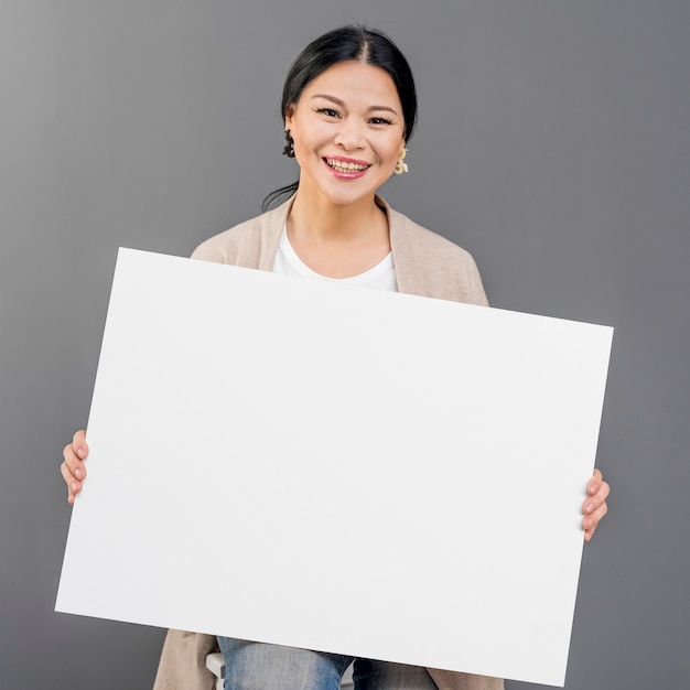 Free photo smiley woman with blank paper sheet