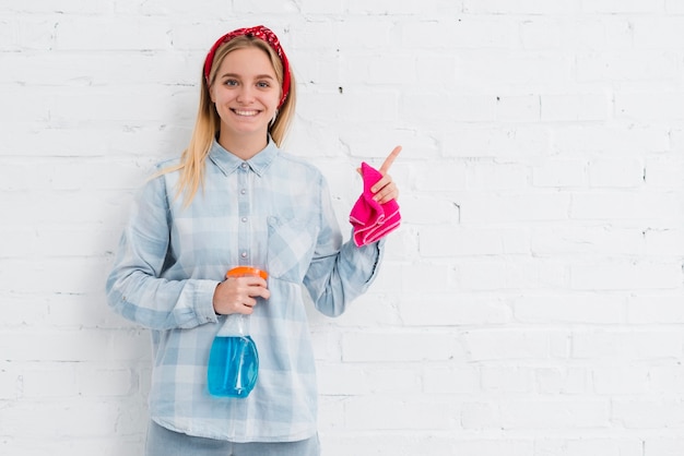 Smiley woman with cleaning products cleaning