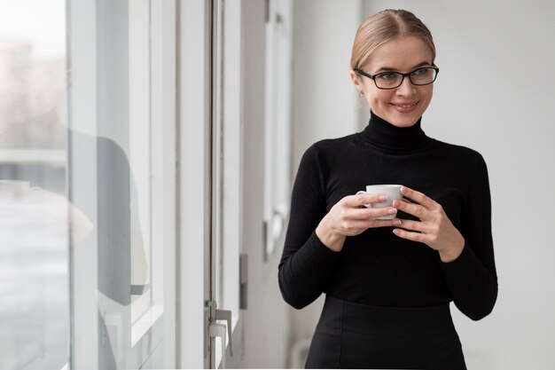 コーヒーカップを持つスマイリー女性