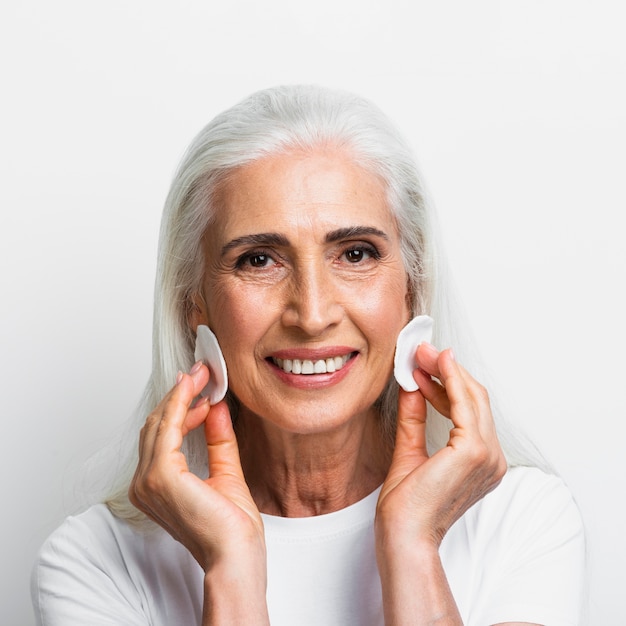 Smiley woman with cotton pads on her face