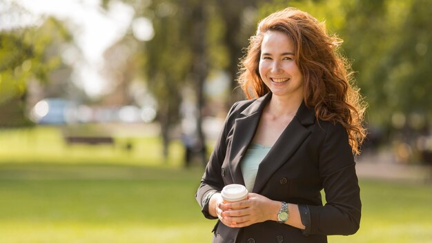 Smiley woman with curly hair posing with copy space