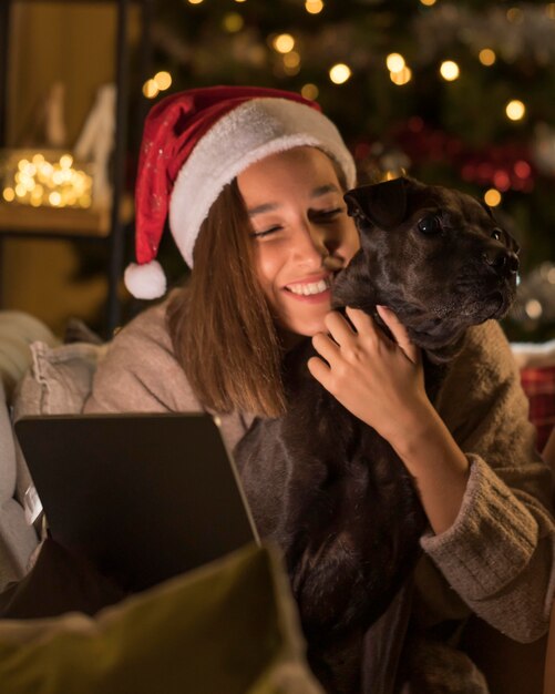 강아지와 산타 모자 태블릿을 들고 웃는 여자