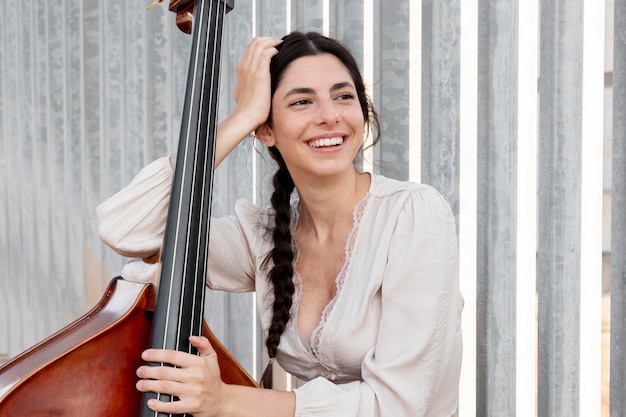 Smiley woman with double bass medium shot