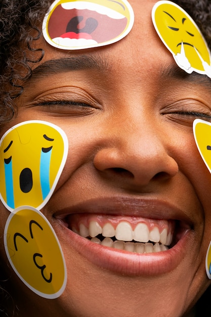 Foto gratuita donna sorridente con emoji sulla vista frontale del viso