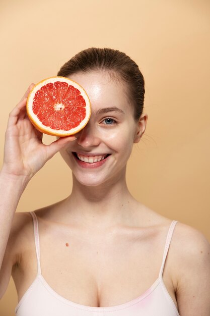 Smiley woman with grapefruit medium shot