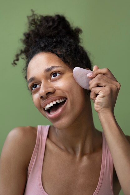 Smiley woman with gua sha side view