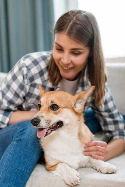 Smiley woman with her dog on the couch