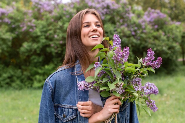 Smiley woman with lilac bouquet