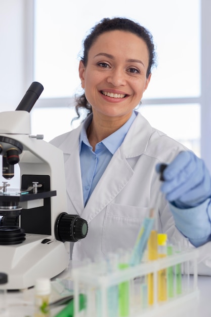 Smiley woman with microscope medium shot
