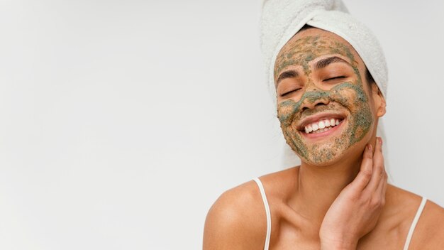 Smiley woman with natural face mask on and copy space