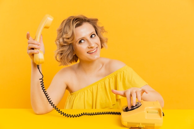 Smiley woman with old phone