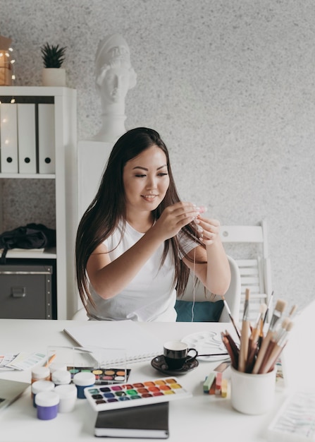 Foto gratuita donna sorridente con tavolozze di pittura