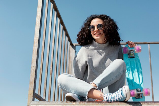 Smiley woman with penny board full shot