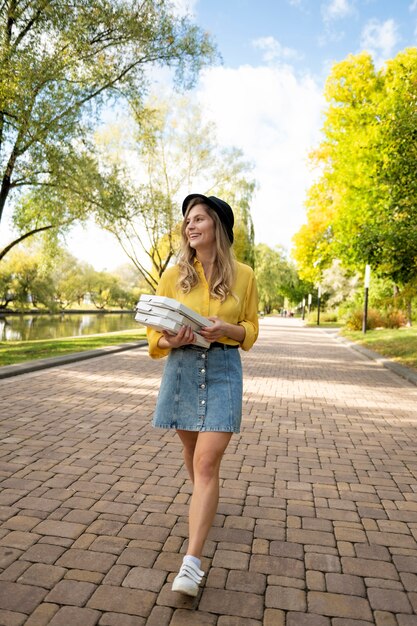 Foto gratuita donna sorridente con il colpo pieno della pizza