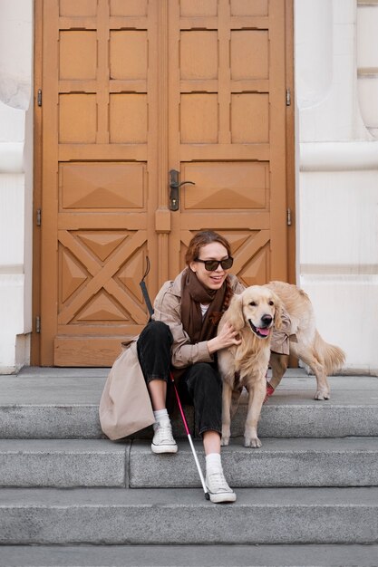 Smiley woman with service dog full shot