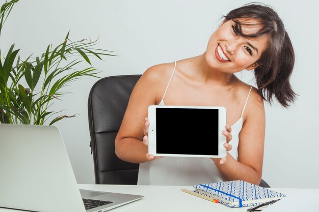 smiley woman with a tablet in the office