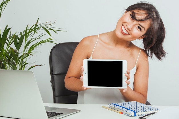 Женщина-смайлик с планшетом в офисе