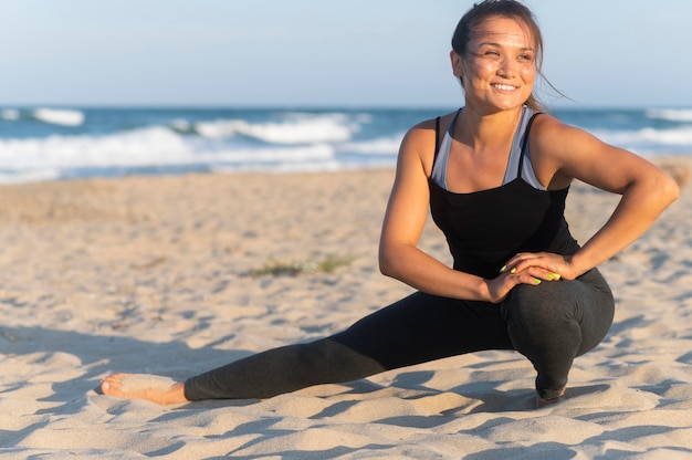 무료 사진 웃는 여자는 해변에서 운동