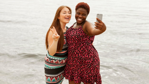무료 사진 selfie를 복용하는 해변에서 웃는 여자