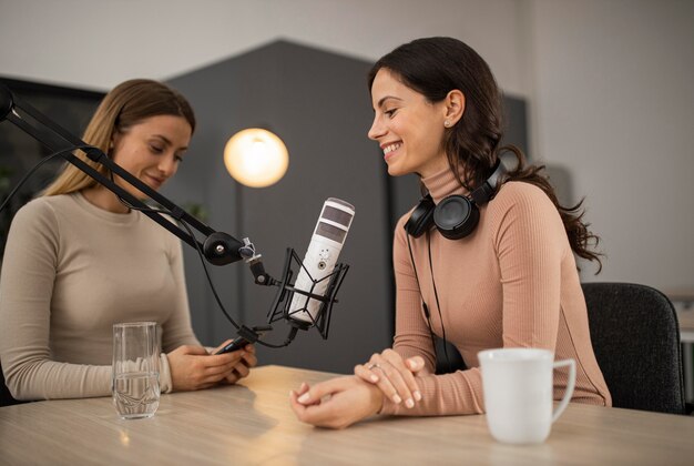 smiley women doing a podcast on radio with a microphone
