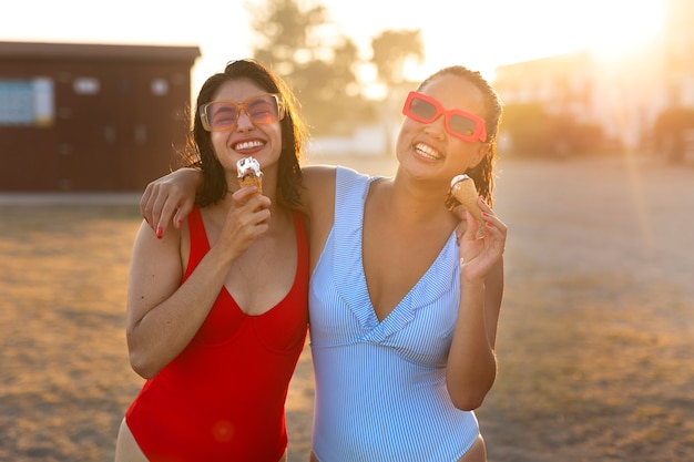 Бесплатное фото Улыбающиеся женщины едят мороженое, вид спереди