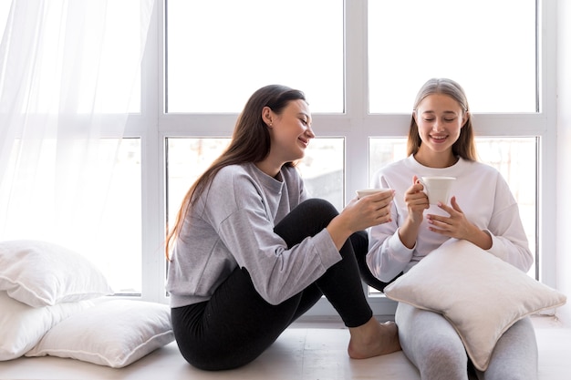 ウィンドウでコーヒーを飲んでいる笑顔の女性