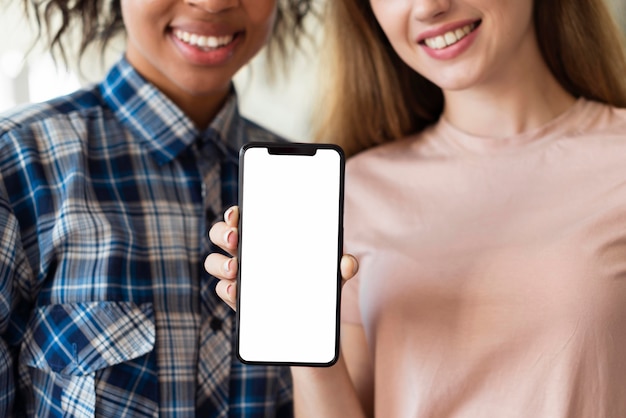 Smiley women holding smartphone with copy space
